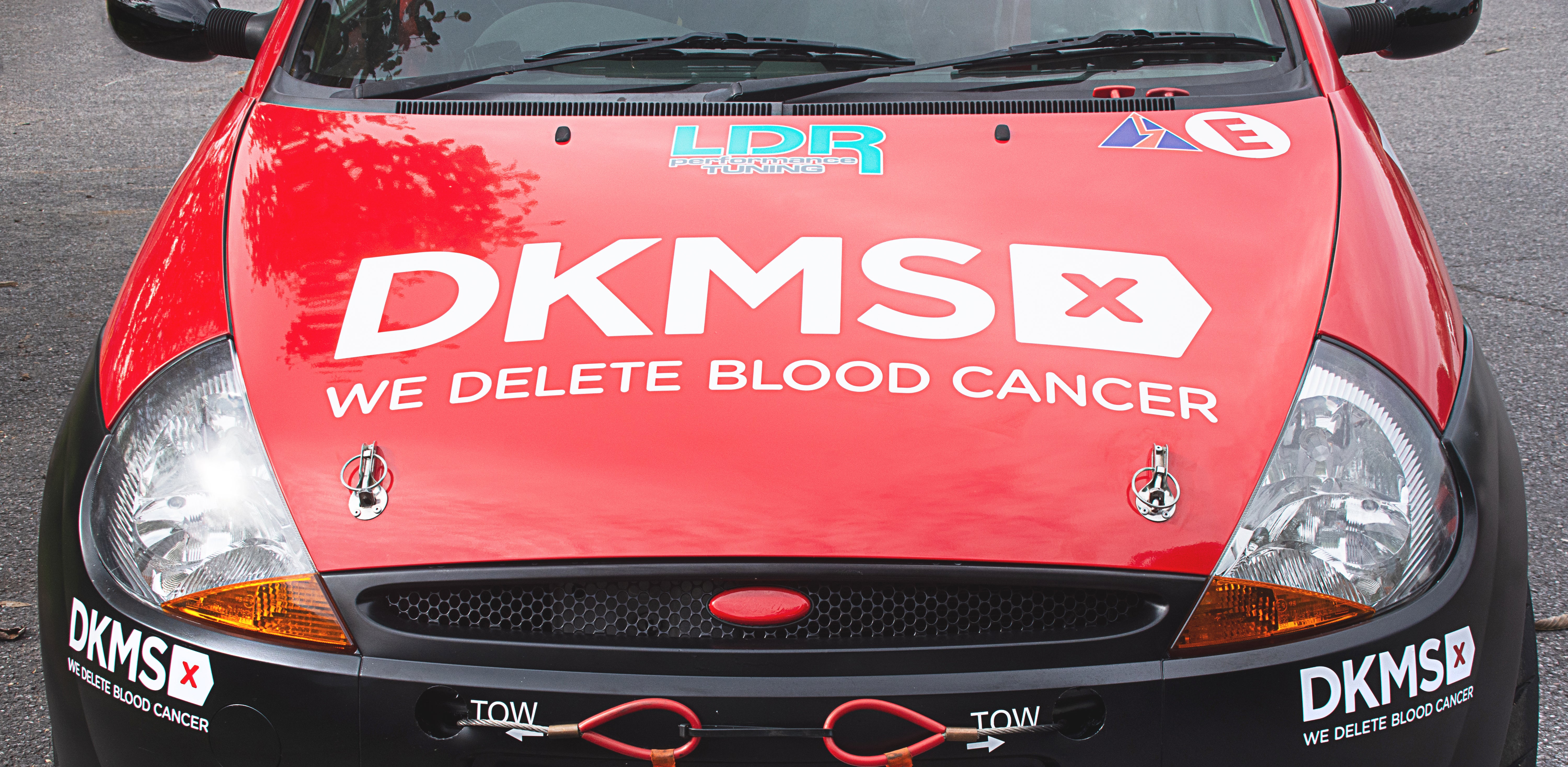 Bonnet of the DKMS car showing the DKMS 'We delete blood cancer' logo