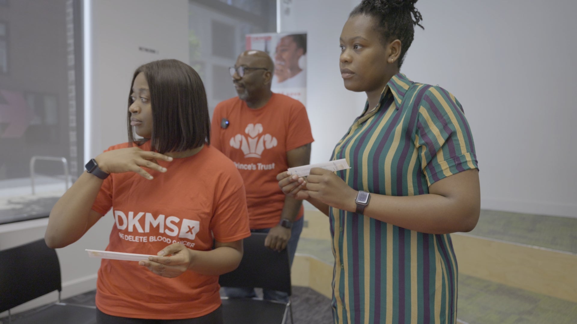 Three African people looking at an event