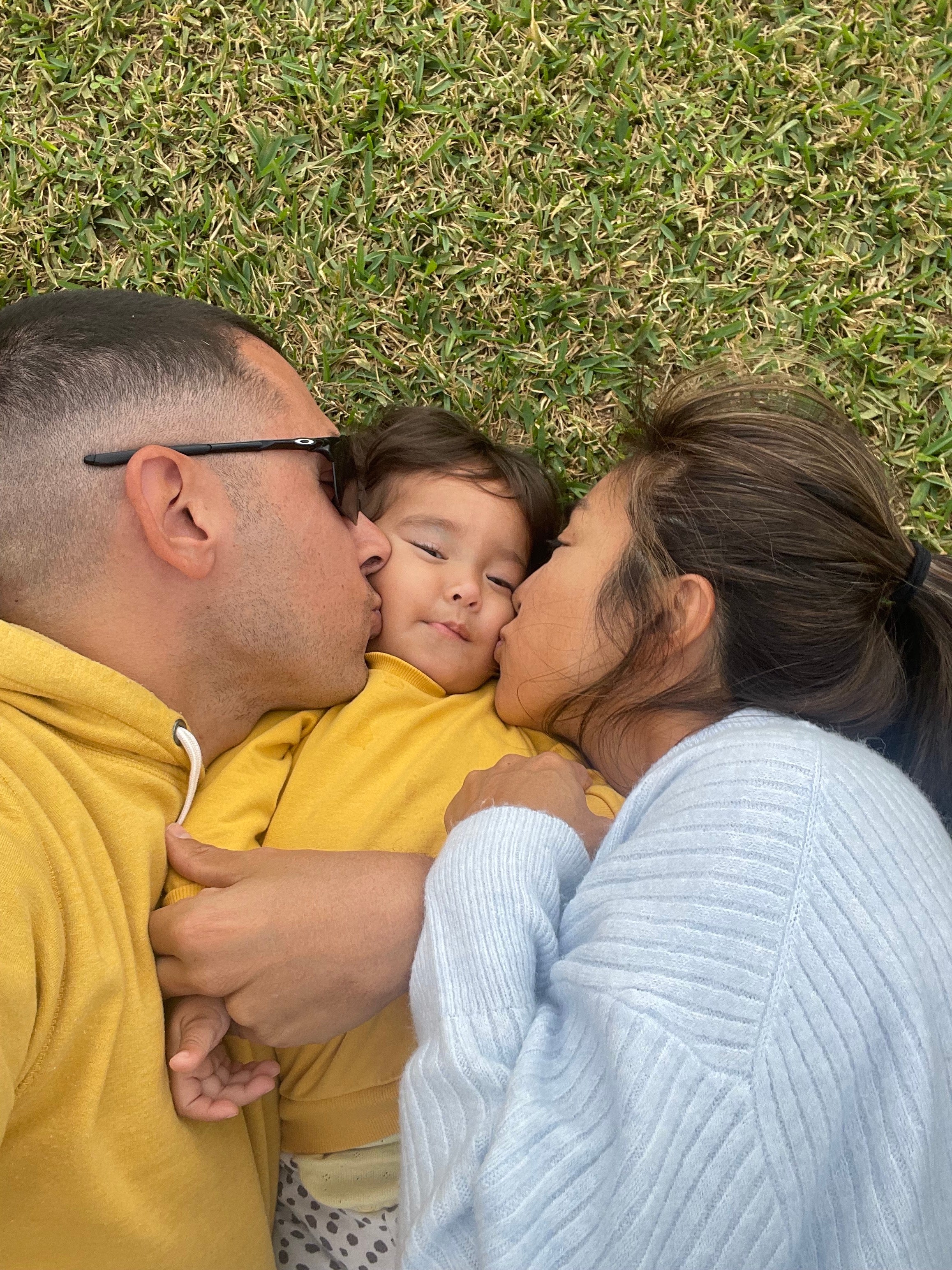 Flaminia's parents kissing her on her cheek.