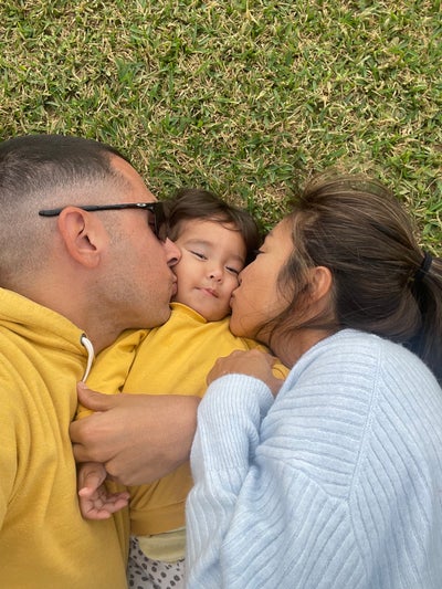 Flaminia's parents kissing her on her cheek.