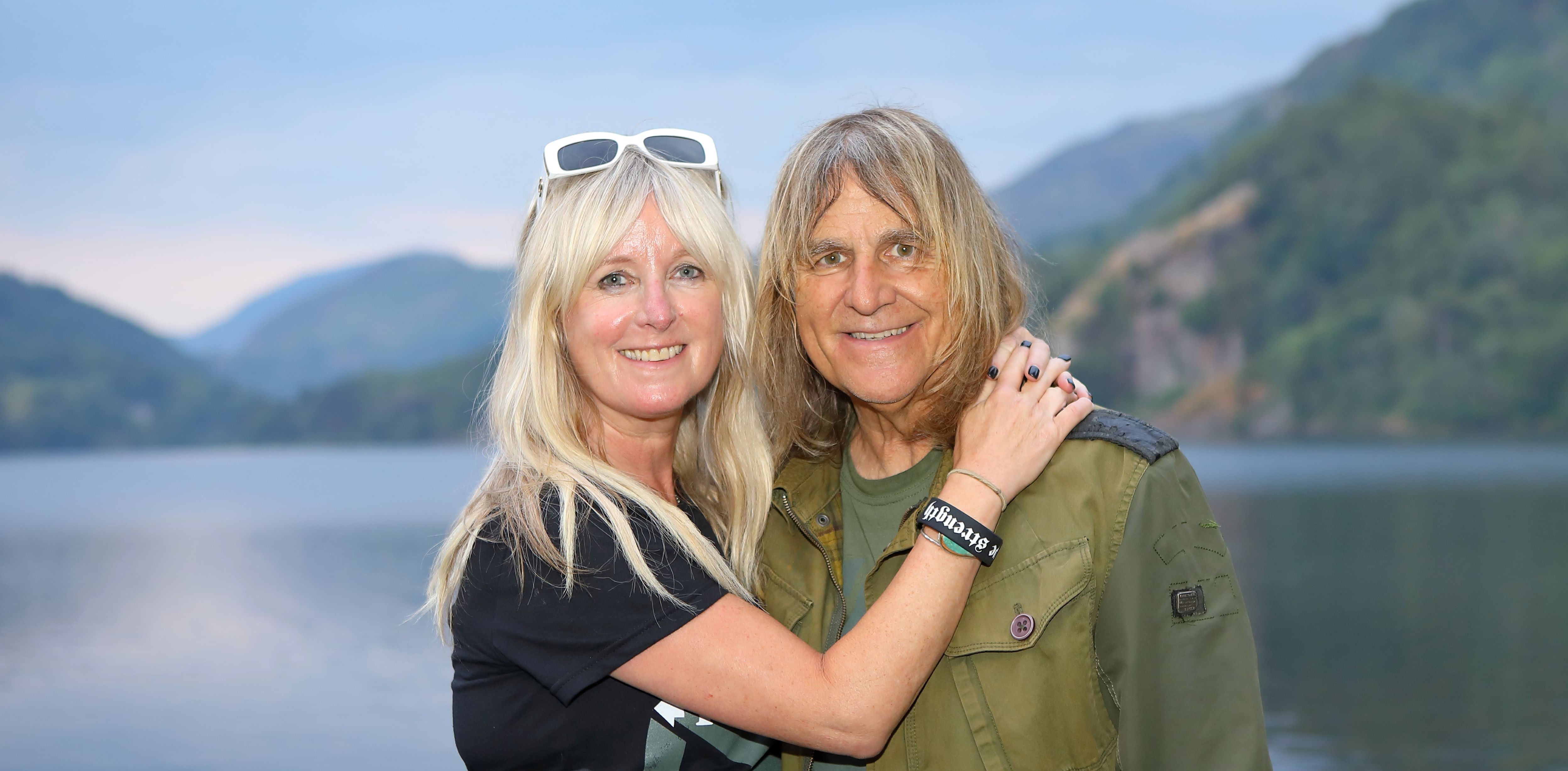 A middle aged white woman and man in front of a lake