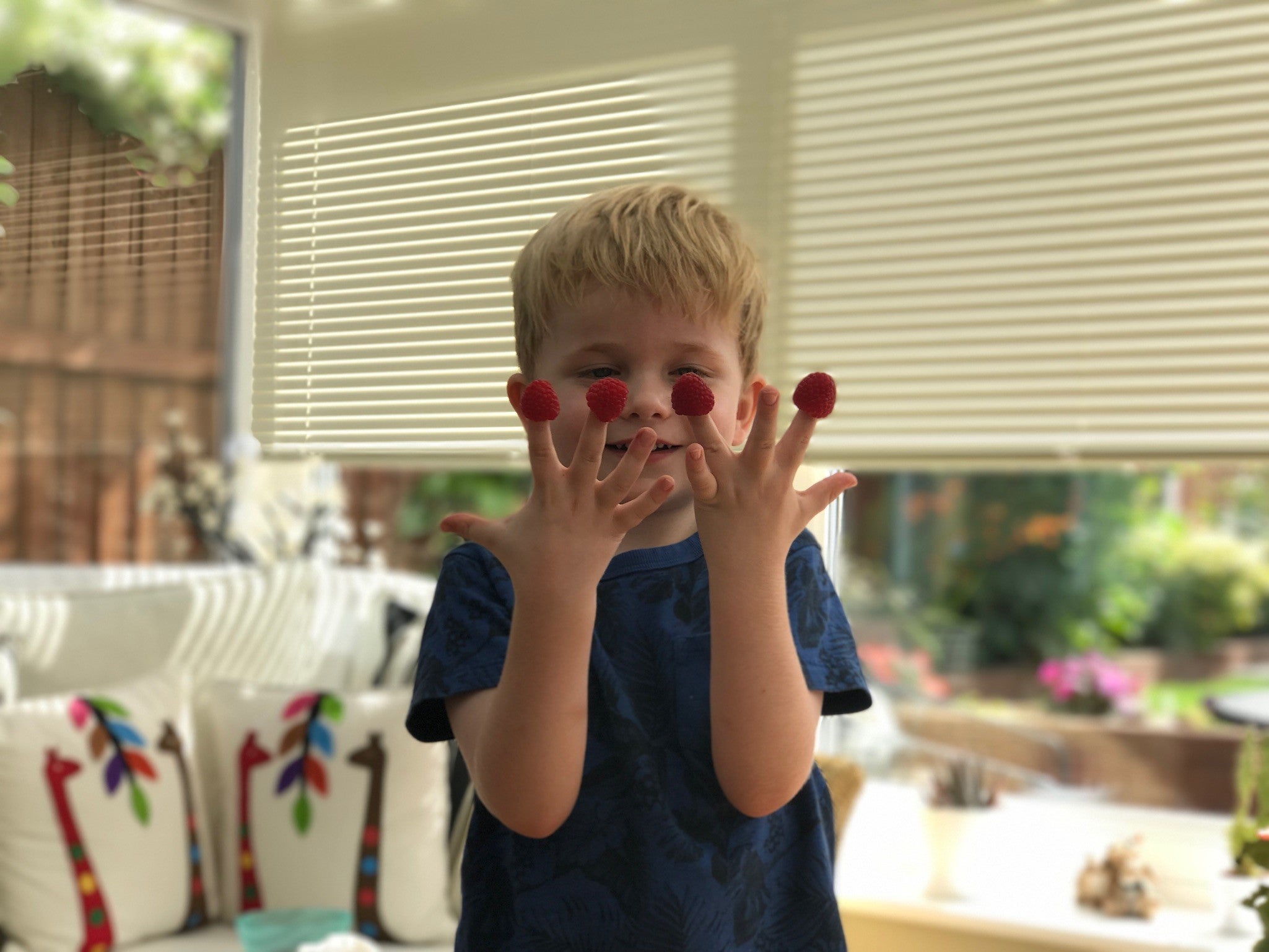 Henry with raspberries smiling at the camera 
