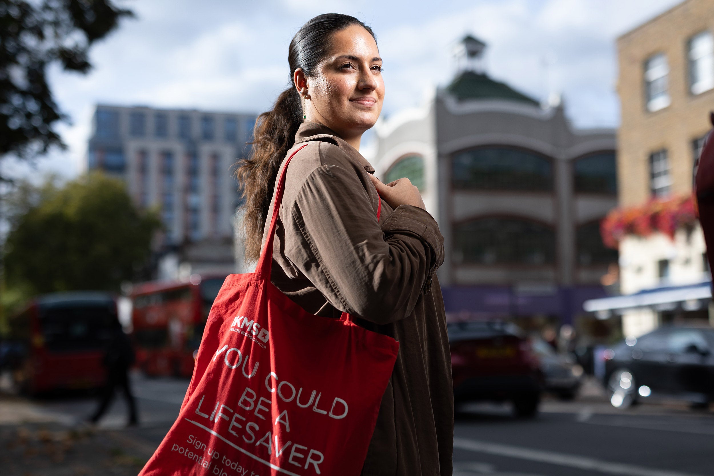 Aliyah on the street with her DKMS tote bag