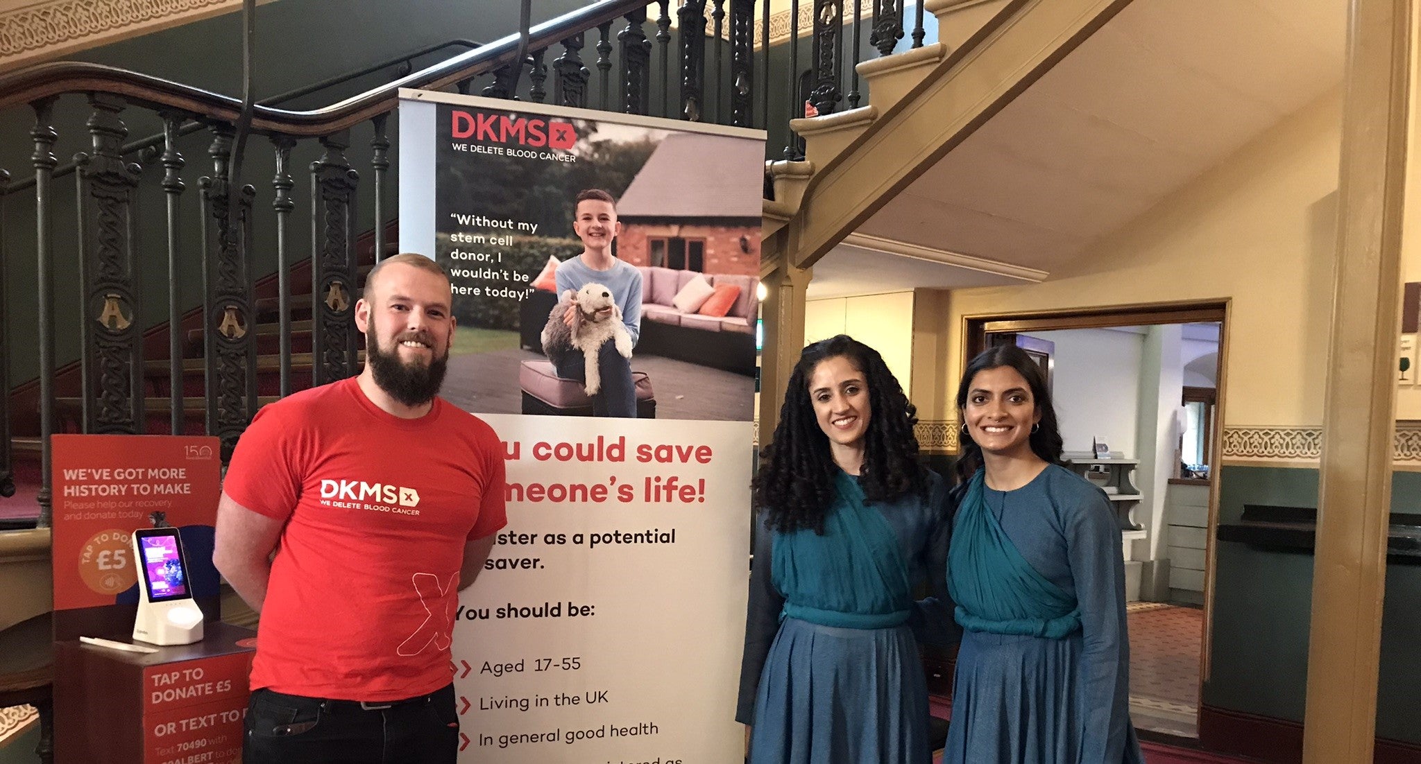 Liam next to DKMS Volunteers at an event