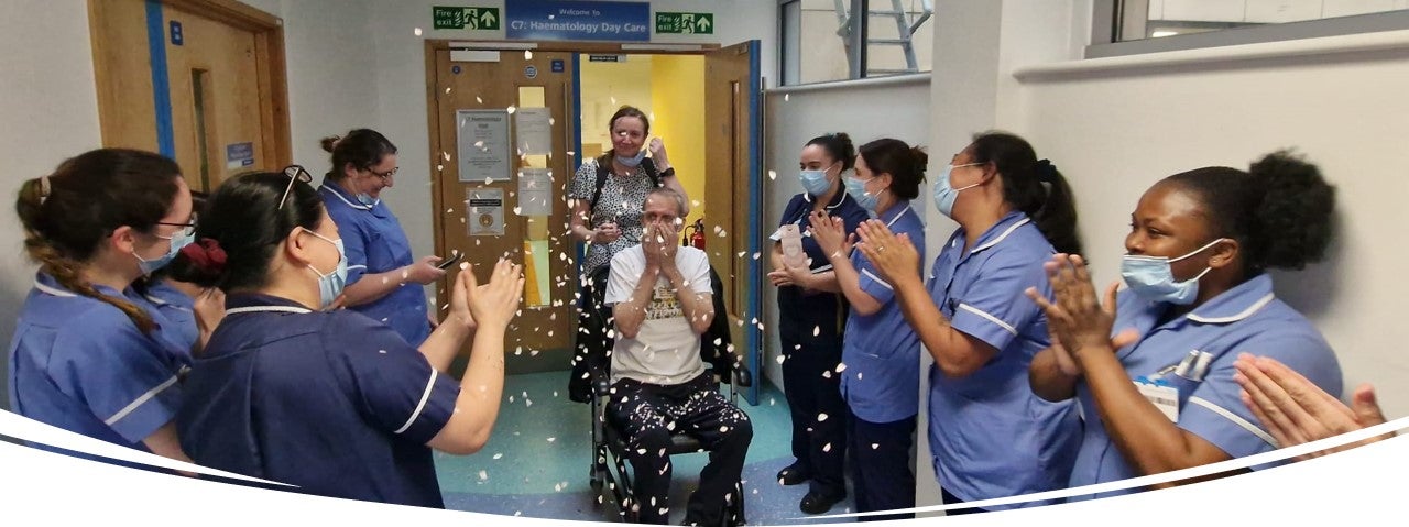 man in wheelchair celebrating leaving hospital