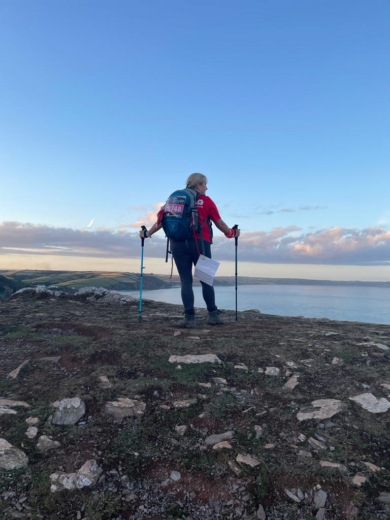 Claire, hill walking with walking poles, looking out over a lake
