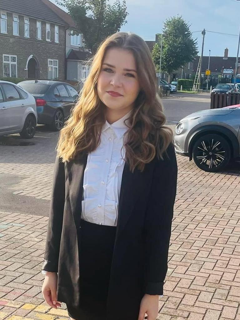 Amber dressed in black suit standing in a car park
