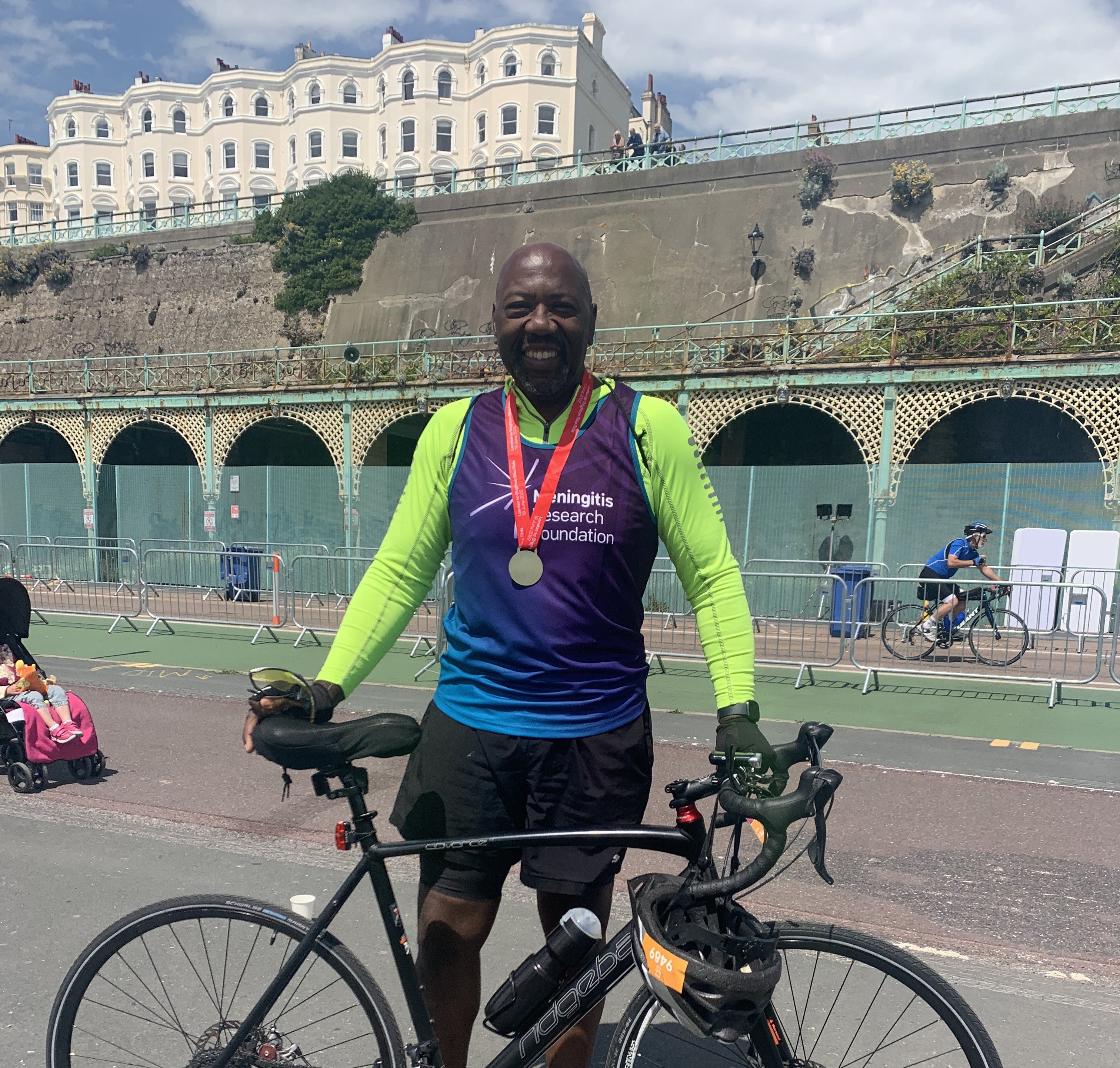 Paul Smith smiling after the Marathon holding his bike