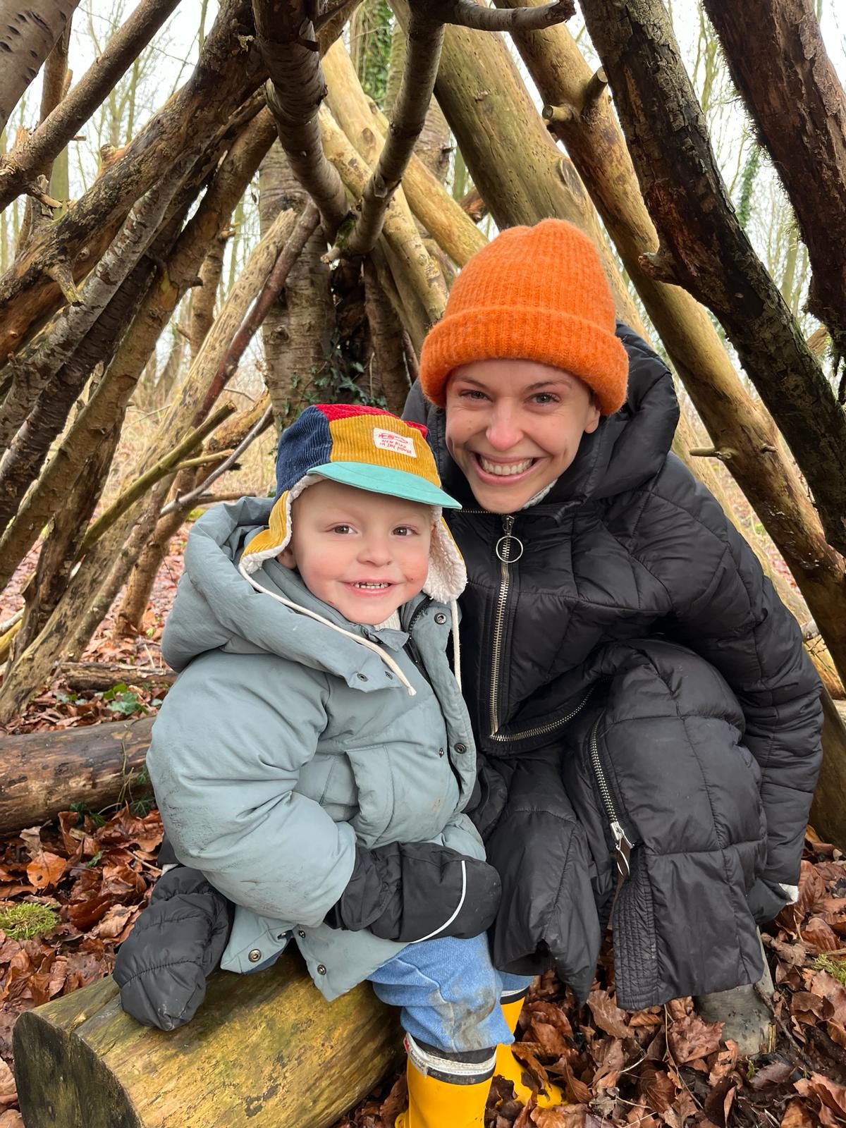 Jo Hughes smiling with her son Oti in the woods