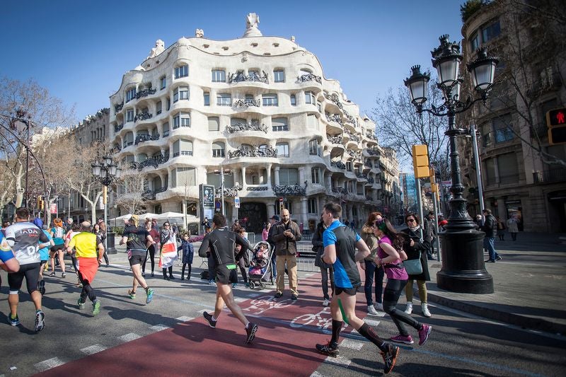 Runners in race in Barcelona, passing by Casa Mila