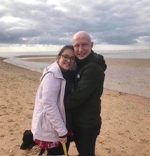 Ben and Amy smiling together on the beach