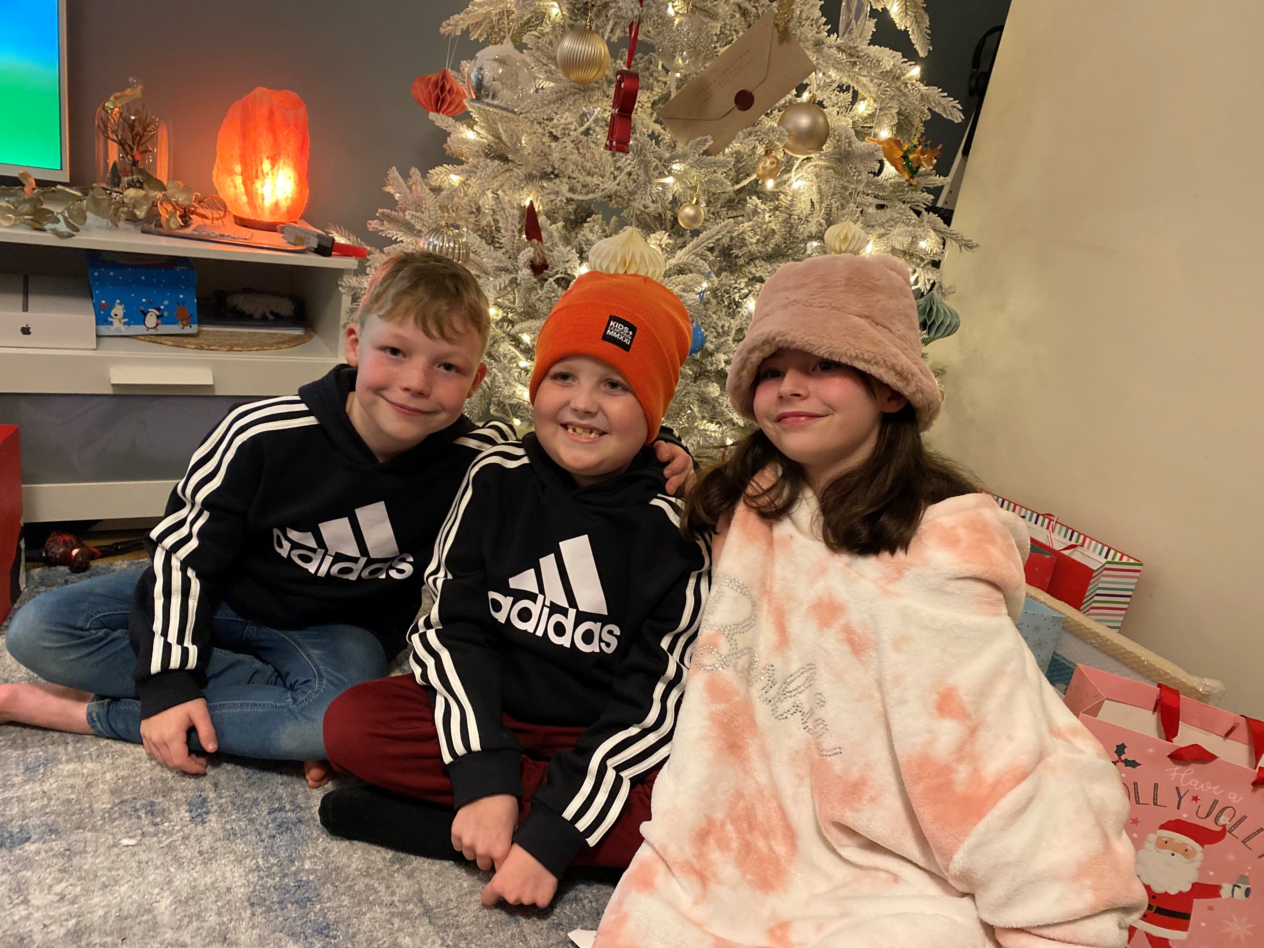 Rufus and others in front of a Christmas tree.