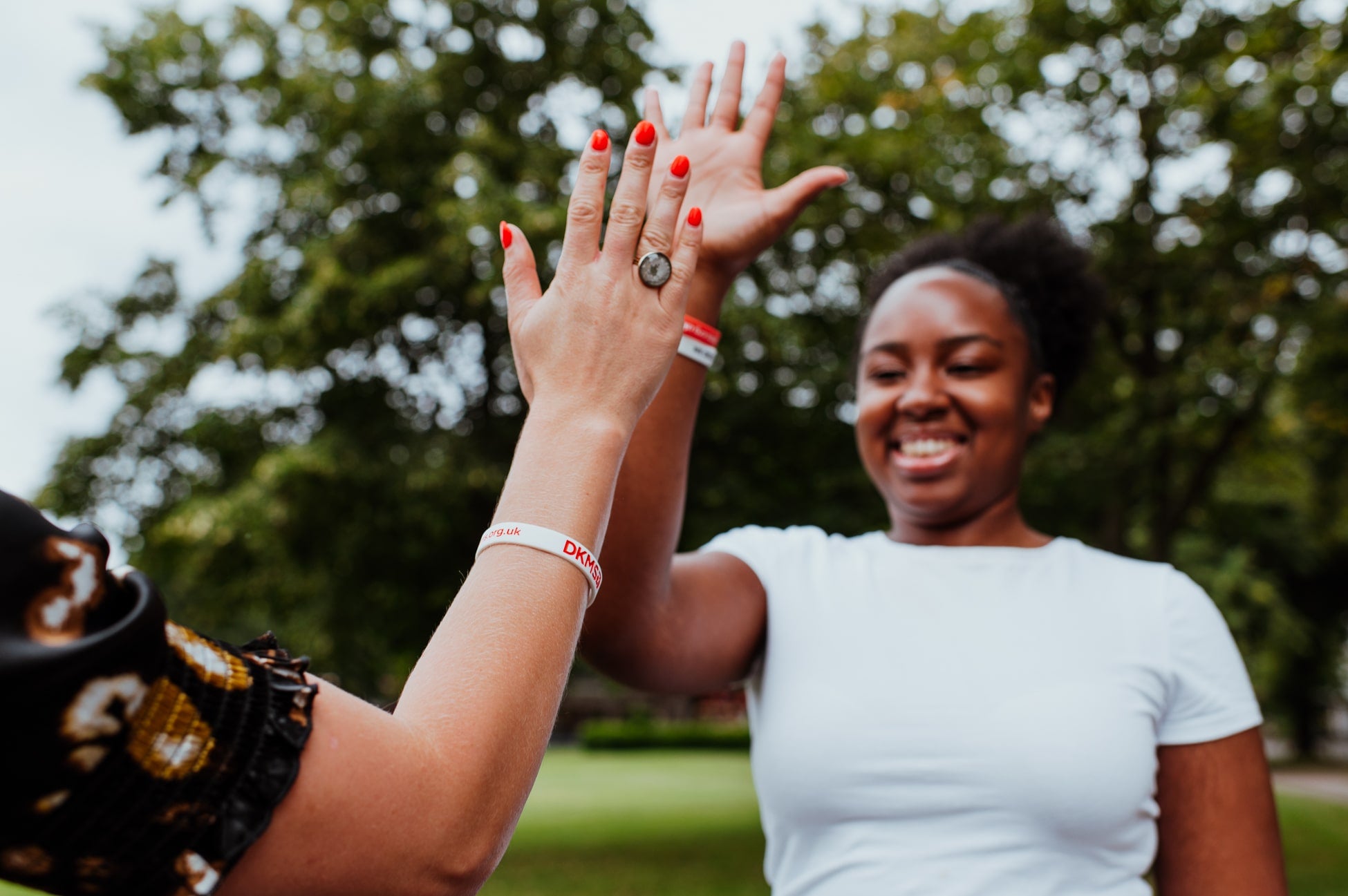 Two young women giving a high five in the park