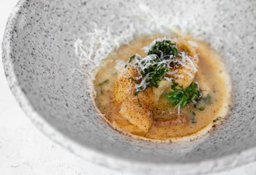 Small dish of food with garnishing in a speckled grey bowl
