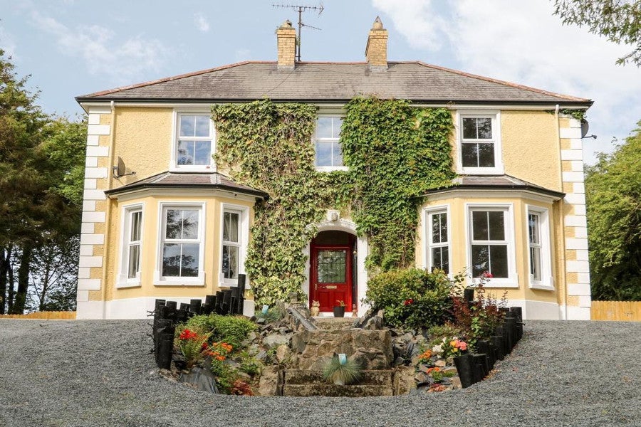 Front view of yellow house with red door