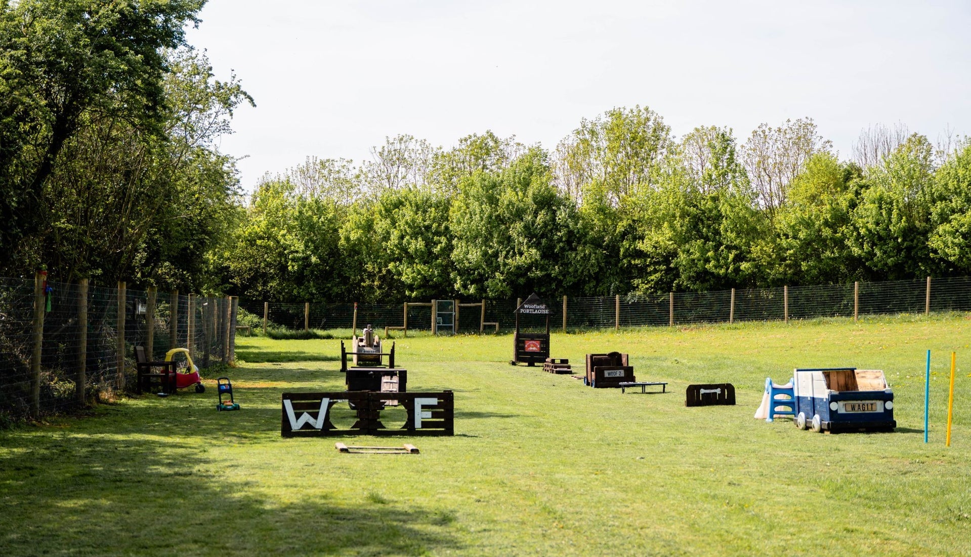 An activity course for dogs with wooden structures on a green field