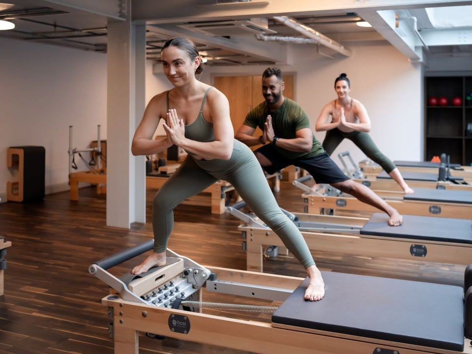Three people balancing on a table while in a yoga pose