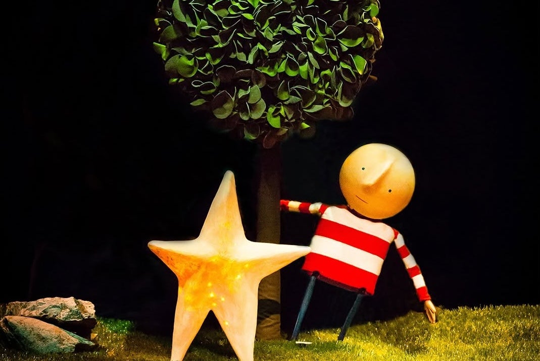 How To Catch A Star, a puppet with bald head and stripy top, swinging from a tree, beside a large gold star.