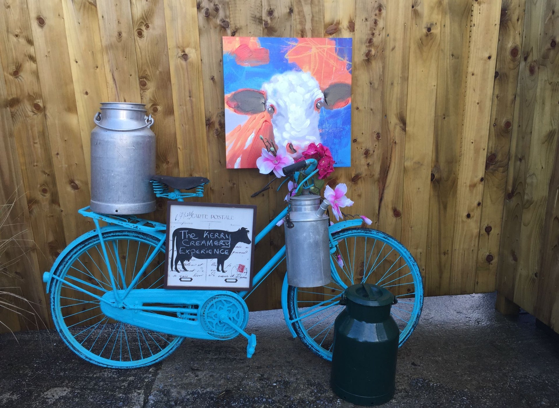 A blue bicycle holding The Kerry Creamery Experience sign at the entrance
