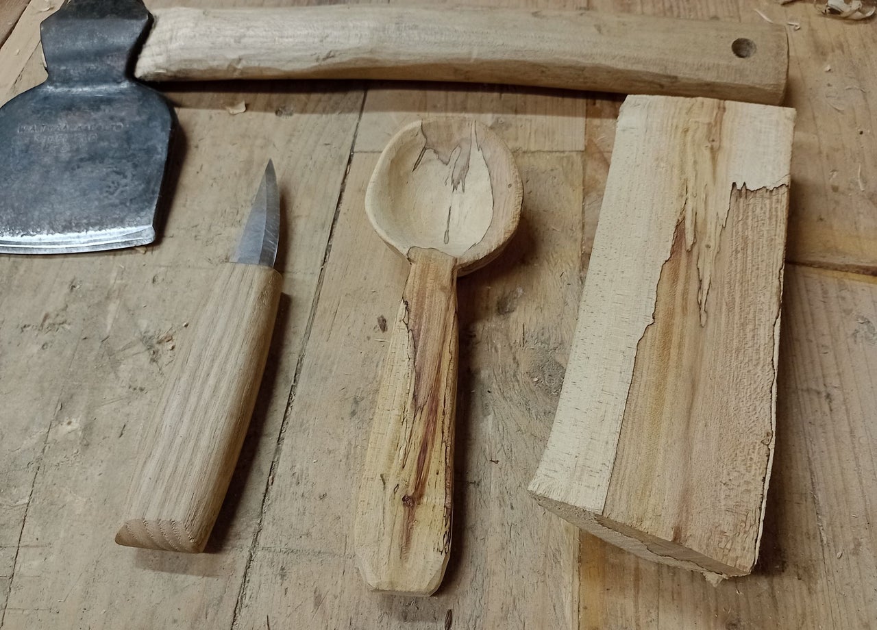 Four hand carved tools laid out on a table