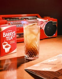 A retro Long Island Iced Barry's Tea cocktail beside a vintage boombox