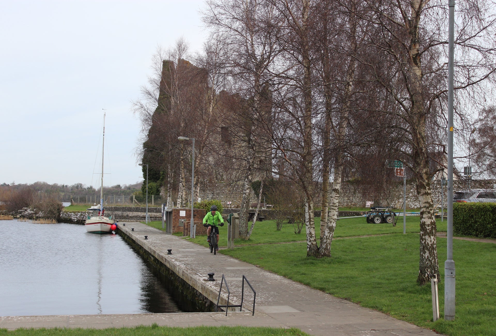 A cyclist on a pier by a lake
