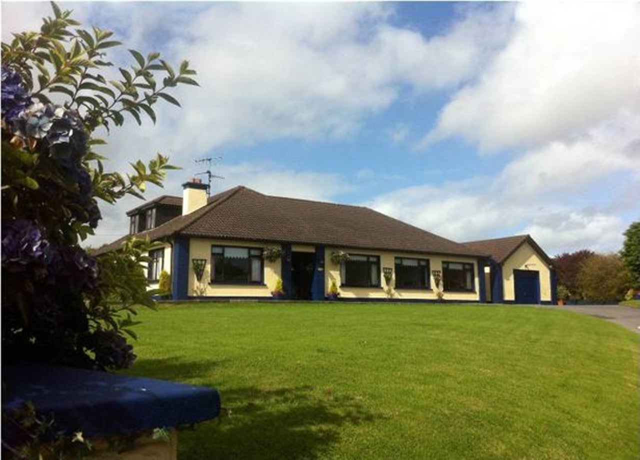 Exterior view of house set on a large lawn.