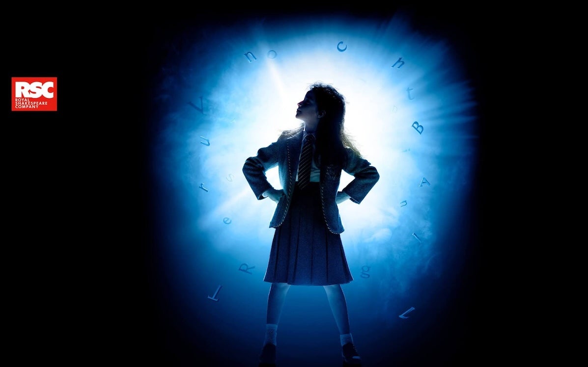 A silhouette figure of a child with their hands on their hips lit from behind with bright light.