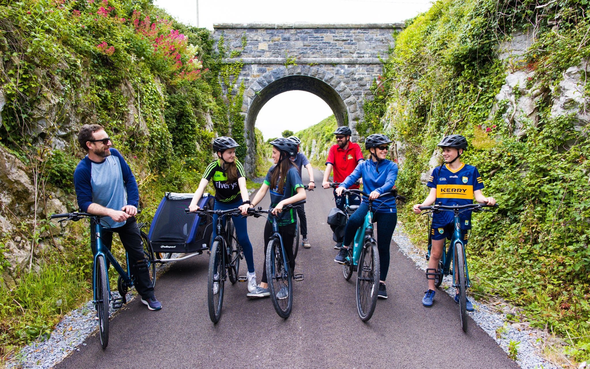 A group of cyclists stopped on a path talking to each other