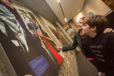 A mother and son looking at a display in a museum