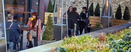 Image of people sitting in a coffee shop looking out onto a garden