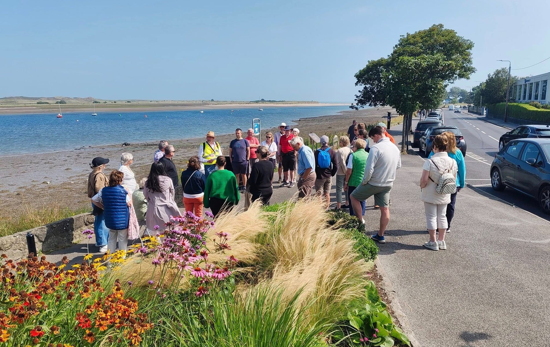 A group of people standing with their walking tour guide on the waterfront in Malahide