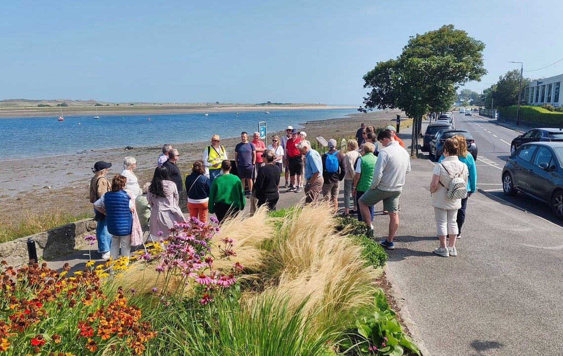 A group of people standing with their walking tour guide on the waterfront in Malahide