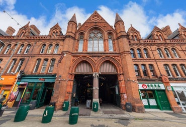 Victorian red brick market building with arched entrances decorative stonework and Gothic style architectural details