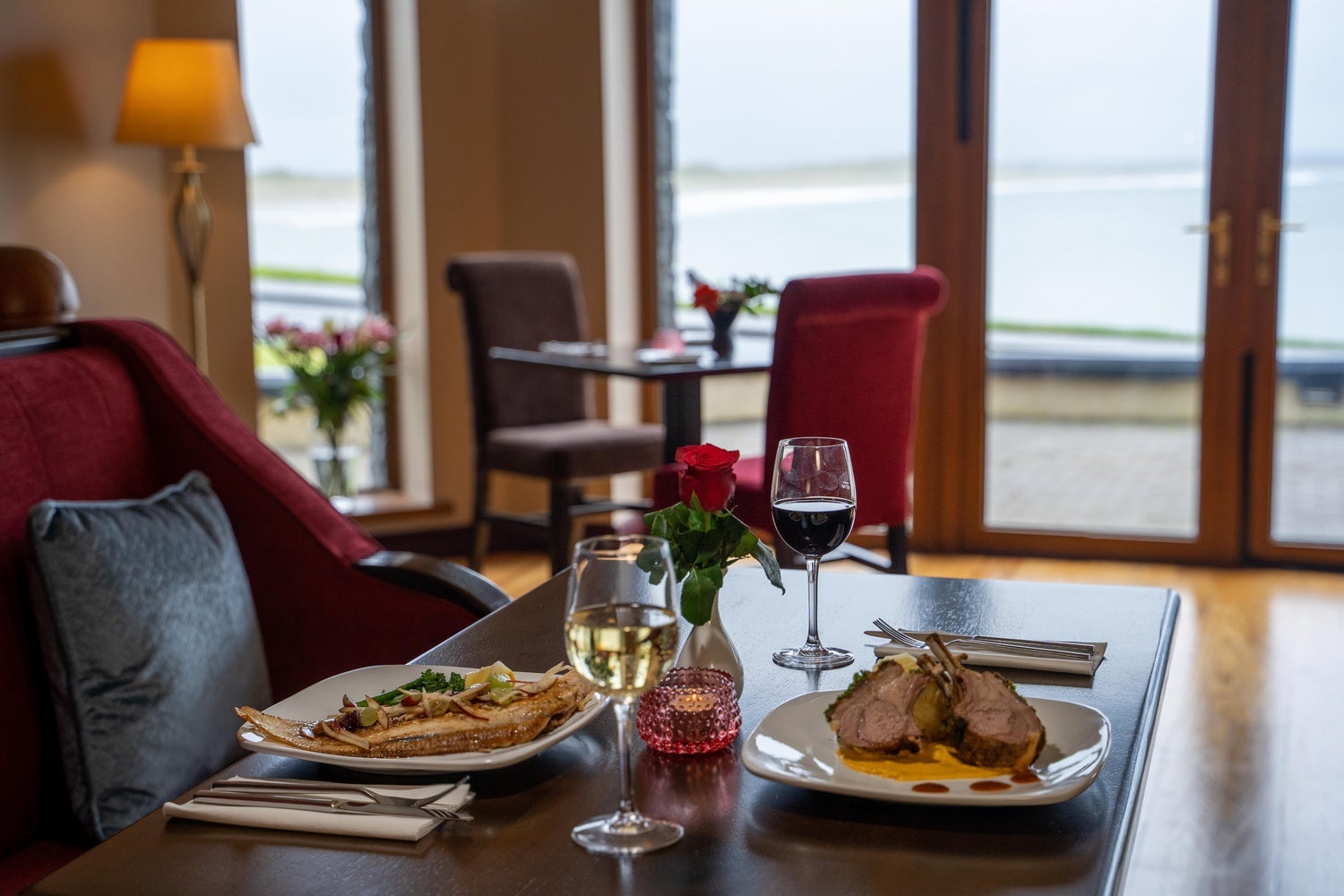 A table set for two people with a view of the ocean