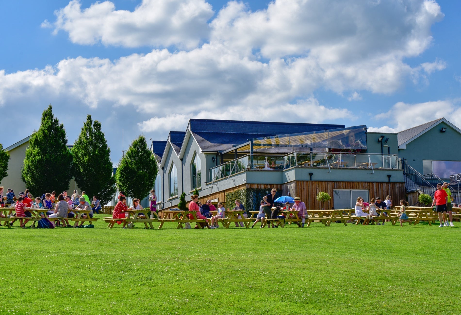 A large group of people sitting at picnic benches