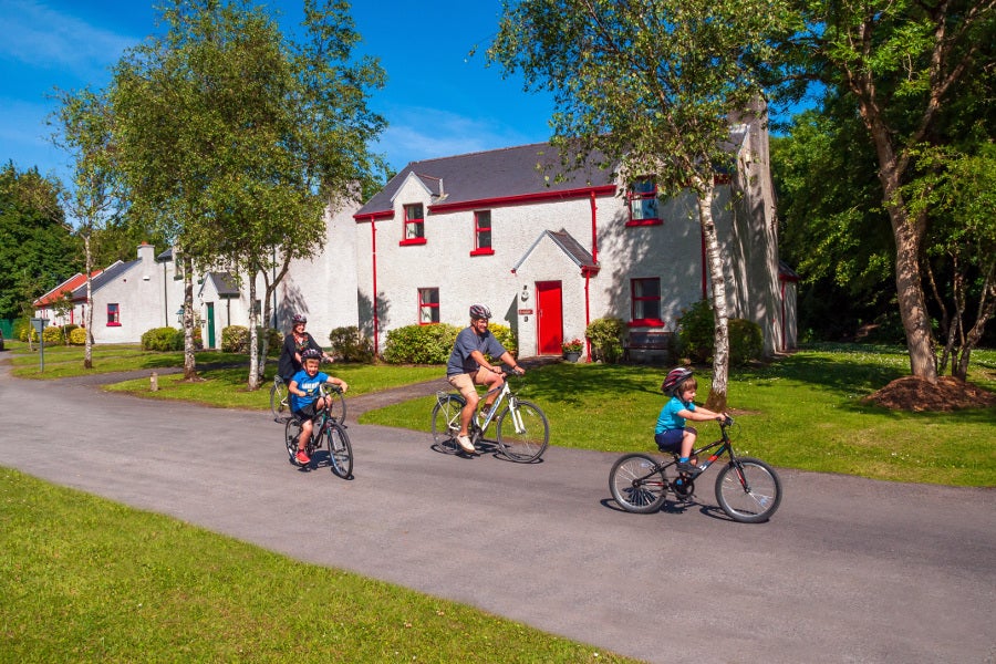Family cycling outside the cottages