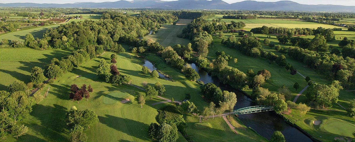 Aerial view of Cahir Park Golf Club green with lots of trees and mountains in the distance