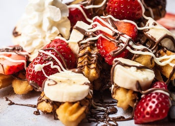 Churros with whipped cream chopped strawberries bananas and melted chocolate at Sweet Churro