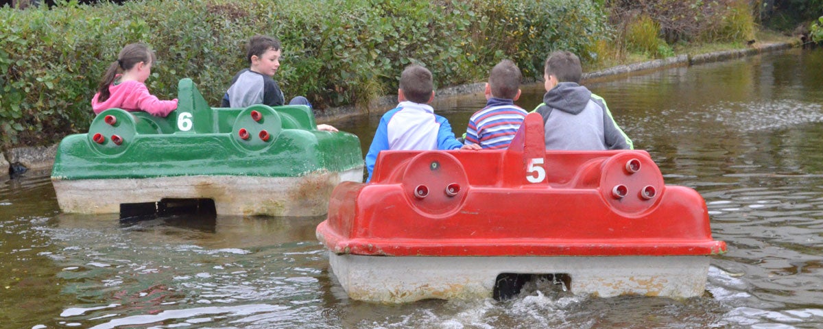 Four children on two small boats on a lake at Ionad Cois Locha at Dunlewey in County Donegal