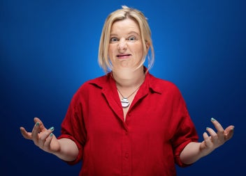 Comedian Sharon Mannion wearing a red shirt with a blue background