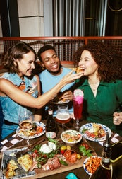 Three people at a table with pasta dishes