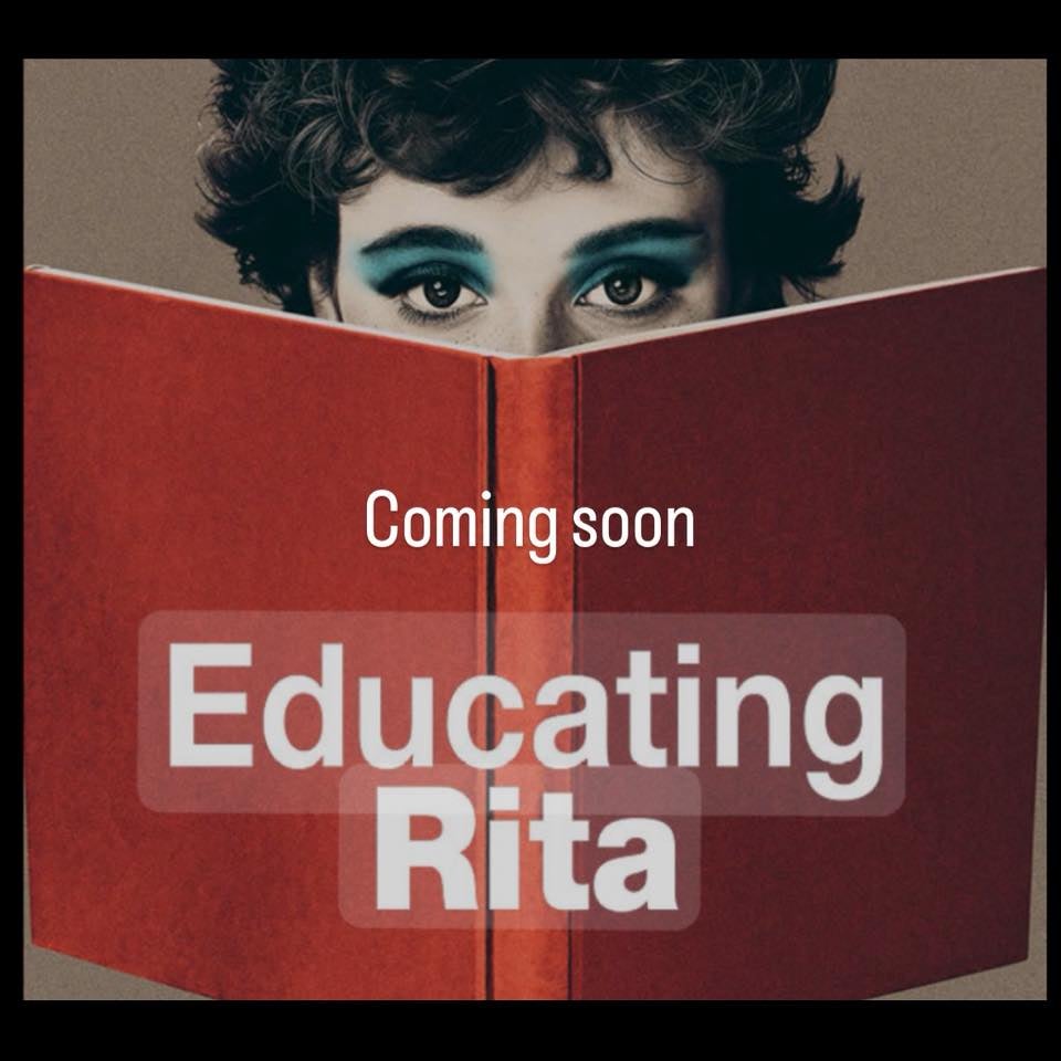 Image of large, open red covered book with woman's eyes appearing at the top