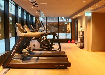 A bright fitness studio featuring treadmills and cardio equipment