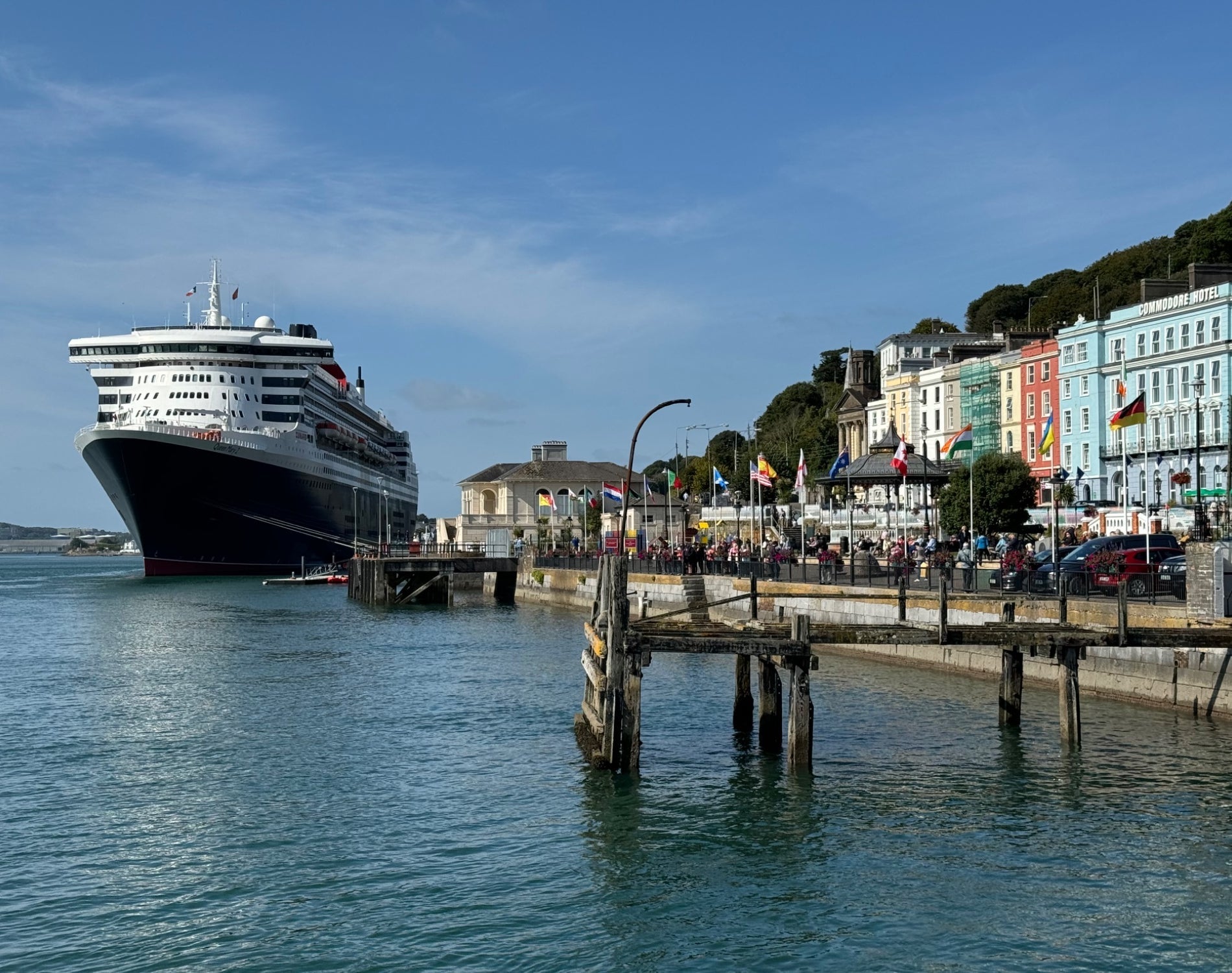 View of a large cruise ship docked at Cobh Cruise Port beside colourful waterfront buildings
