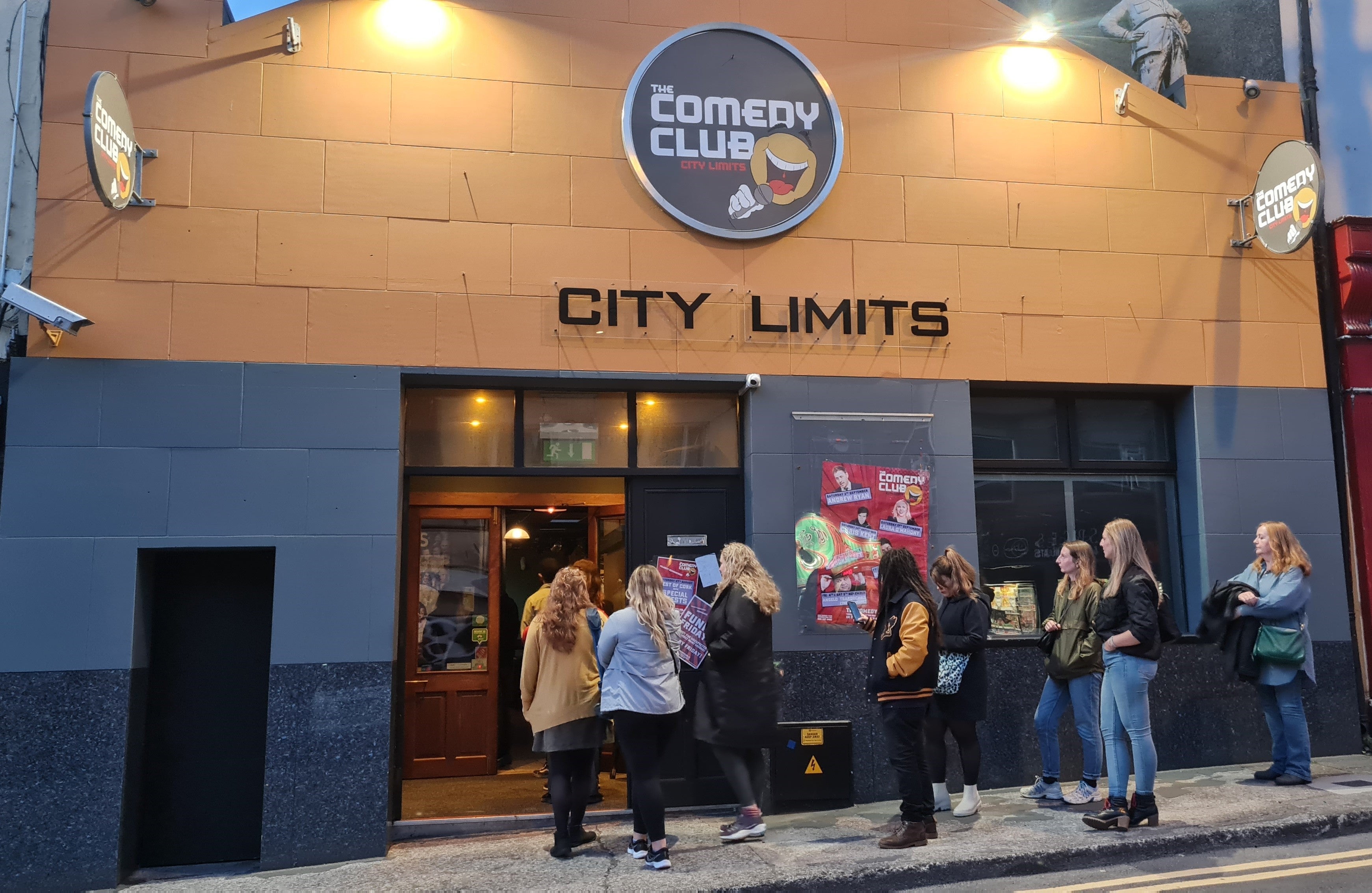 Best of Cork November Autumn Special - people queueing outside a building at night.