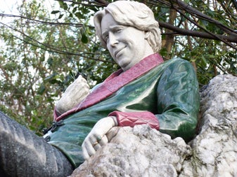 A close-up of the famous Oscar Wilde statue in Merrion Square, Dublin, capturing his sculpted smirk and colourful jacket carved from multicoloured stone — a striking tribute to the city's most celebrated wit.