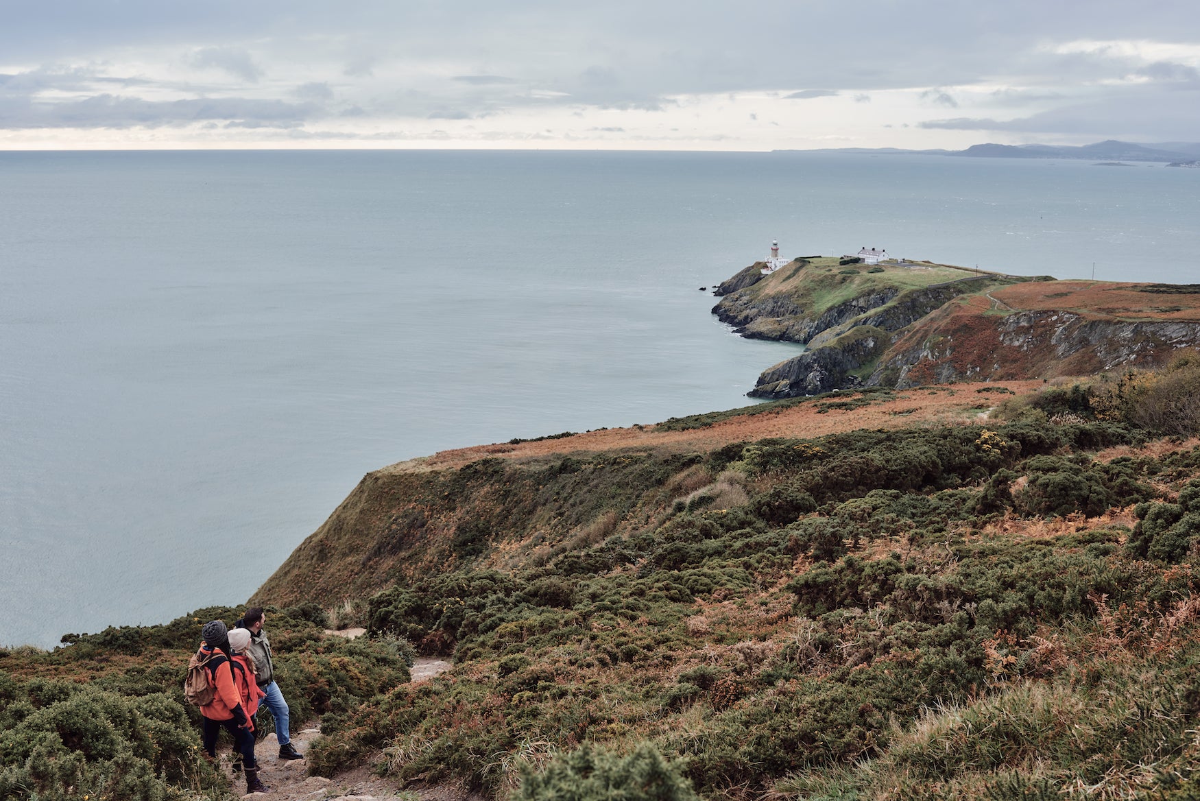 Aerial image of three people hiking along the Howth Cliff Walk in Howth, County Dublin