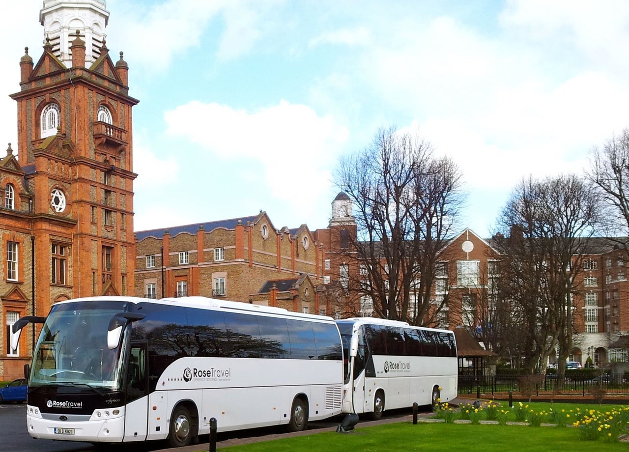 Two tour buses parked outside a building