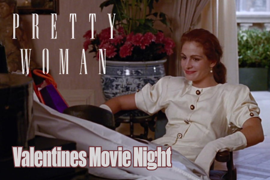 A seated smiling woman in a posh cream suit